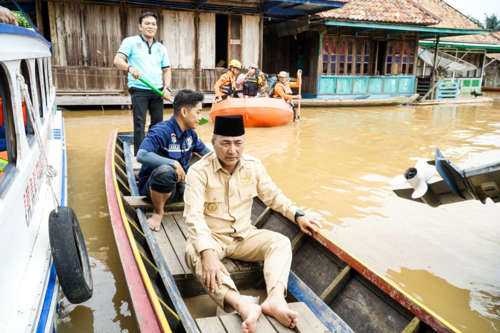 Naik Perahu, Pj H Apriyadi Tinjau dan Beri Bantuan Korban Banjir di Ulak Embacang